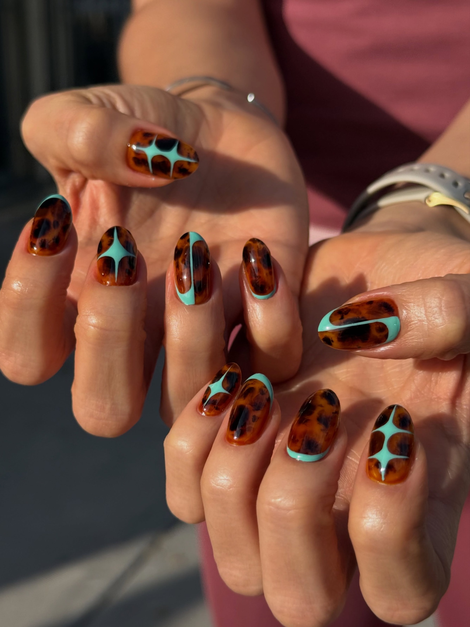tortoiseshell nail art mixed with bright turquoise blue designs on long oval nails