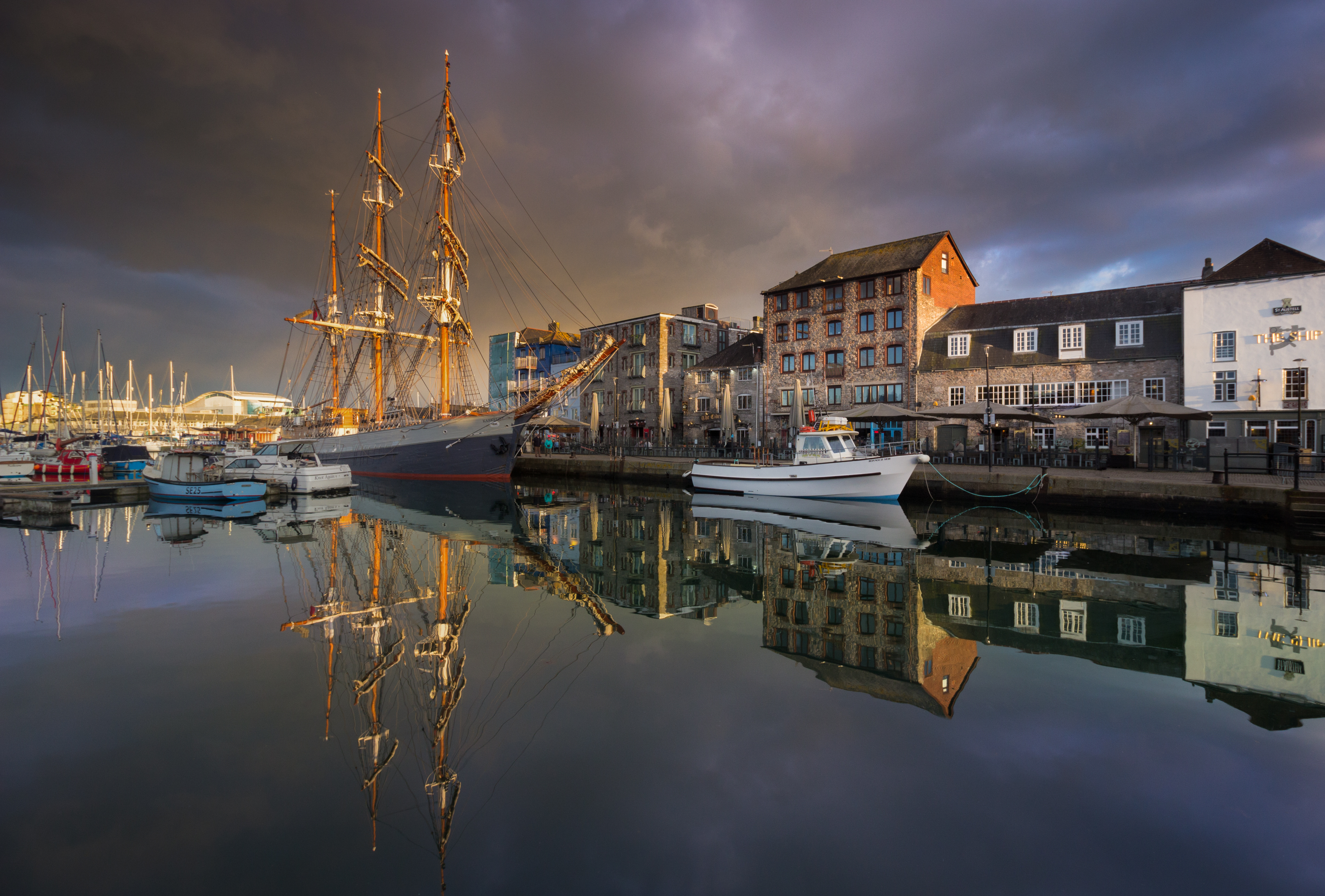 Large sailing boat, Kaselot, resting in Plymouth's Barbican on a still evening