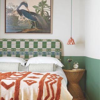 Two-tone green and white painted bedroom with a patterned upholstered bed frame