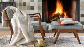 A chair with a blanket draped on it in front of a fire