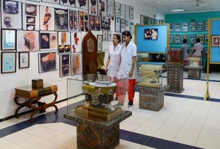 Two female nursing students walk by toilets at the Sulabh International Toilet Museum in New Delhi