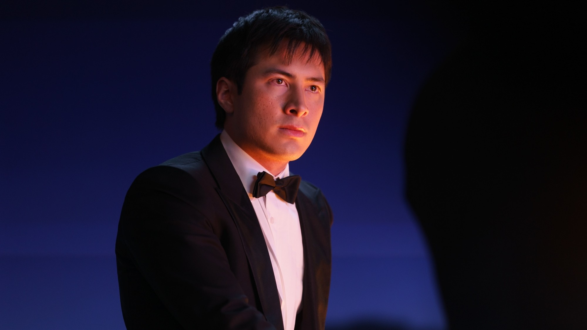 Hudson Williams as Shane Hollander wearing a tux on Heated Rivalry.