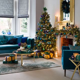 living room with christmas tree and green sofa
