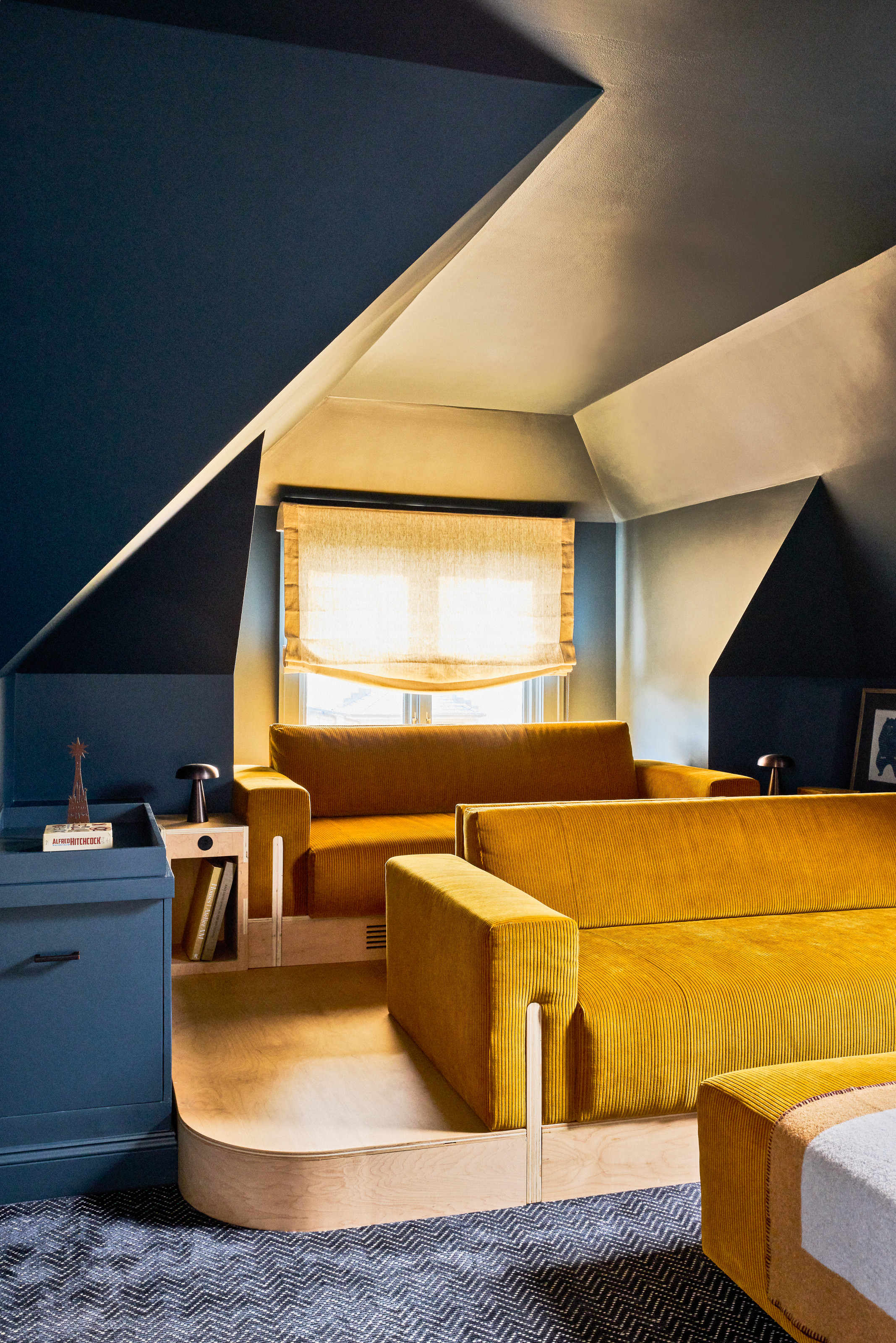 Cinema room with navy walls and mustard yellow chairs built in to joinery