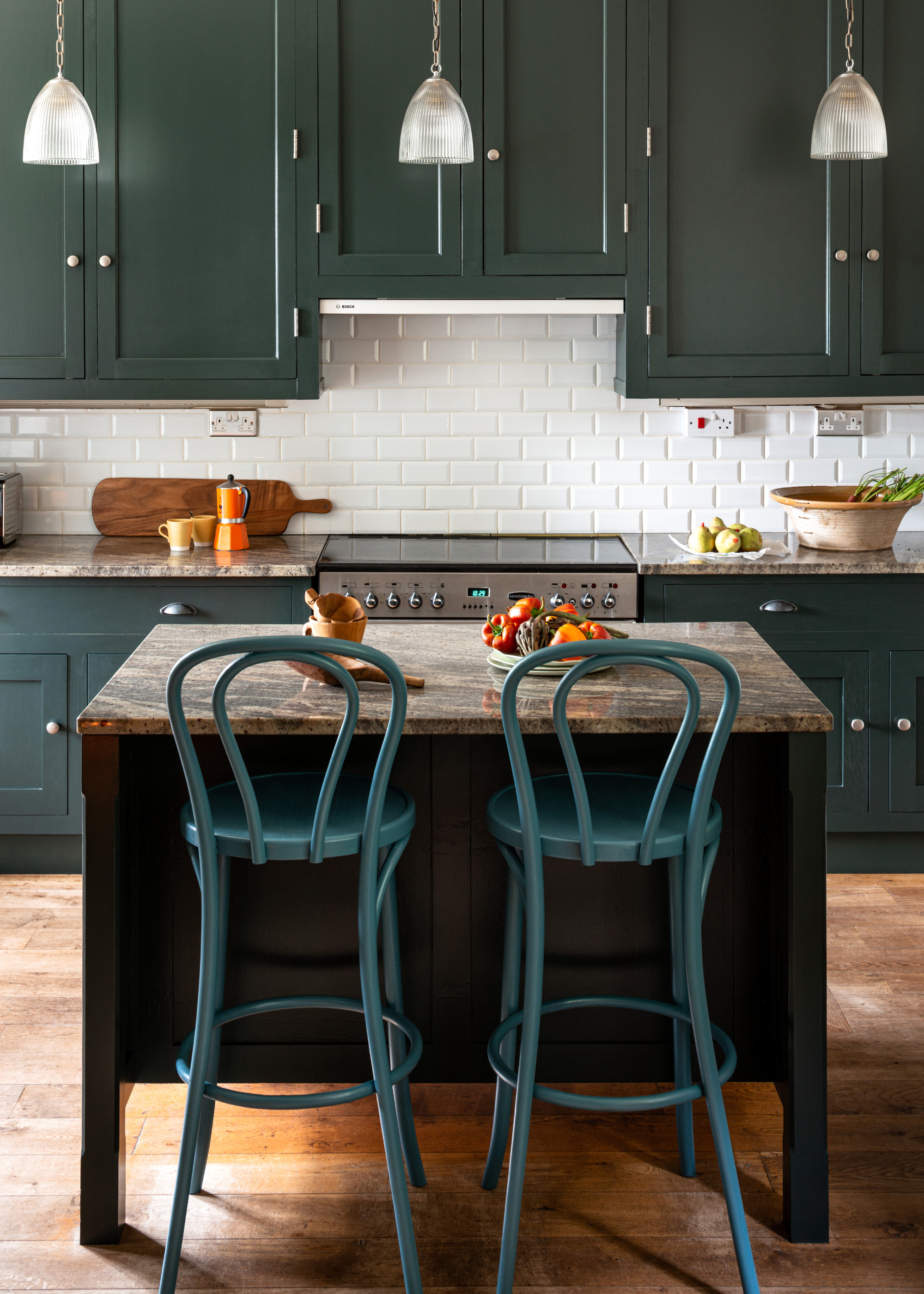 small kitchen with dark green cabinetry and a square island in the middle