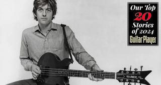 Portrait of musician Nick Lowe playing a Hamer guitar, circa 1990. 