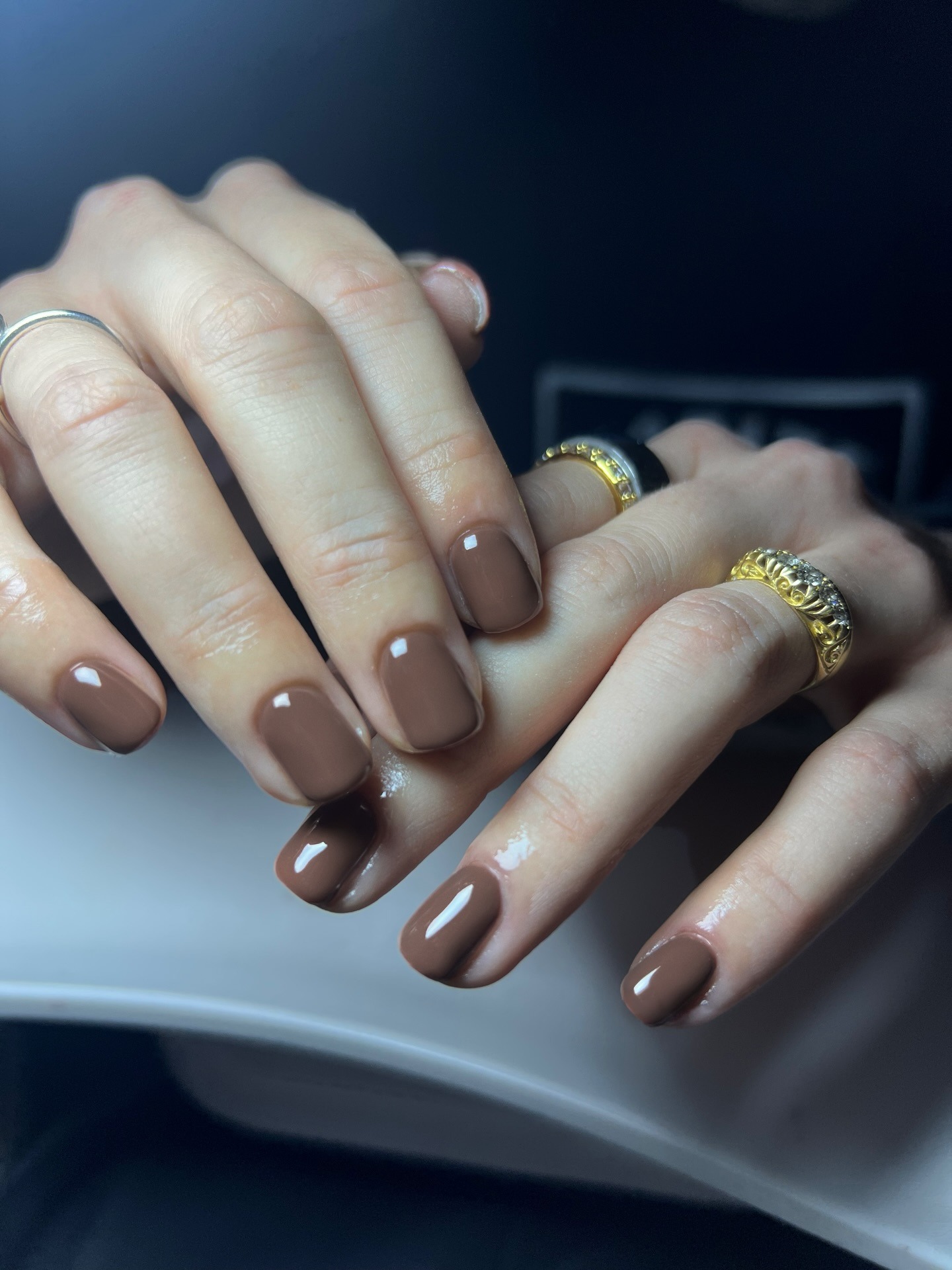 A short, chocolate brown manicure