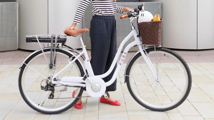 Woman standing beside Pure Free Step e-bike