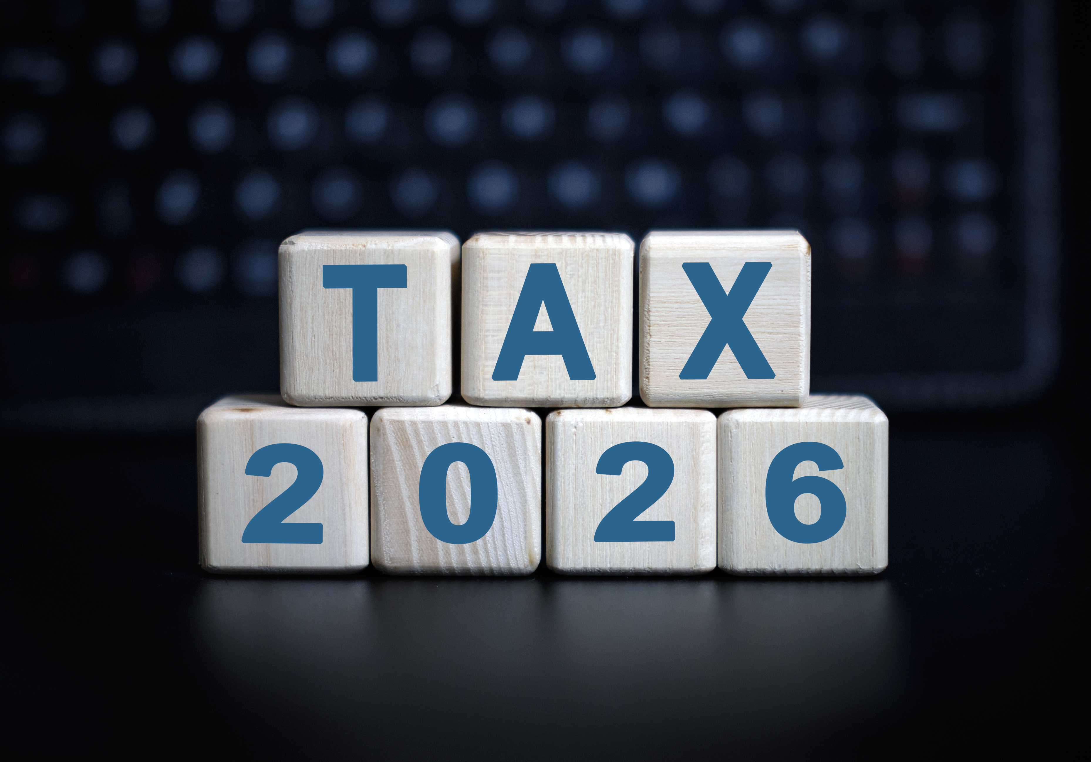 "tax 2026" on wooden blocks against a dark background