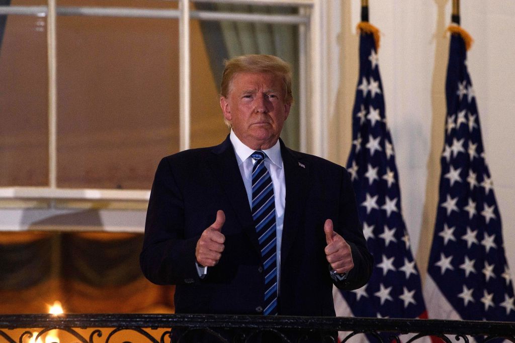 President Donald Trump gives two thumbs up from the Truman Balcony upon his return to the White House from Walter Reed Medical Center, where he underwent treatment for Covid-19, in Washington