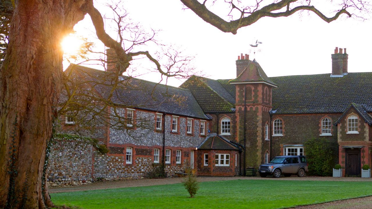 An exterior shot of Kate and William&#039;s country house Anmer Hall at sunset with a tree framing the top of the house