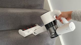 The Roidmi Z1 Air being used in handheld mode to clean carpeted stairs