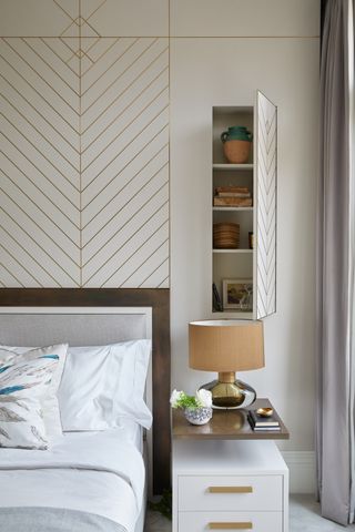 neutral bedroom with hidden overbed storage, modern bedside, gold detailing on wall