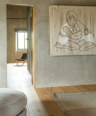 hall with gray walls, artwork of children, wooden floor, taupe rug and off white stool