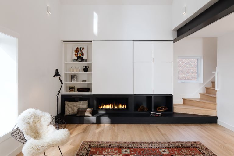 A living room with black fireplace and white walls