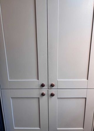 tall grey kitchen larder unit with wooden knobs