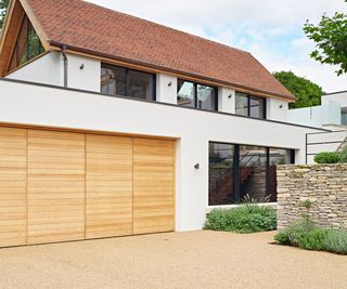 resin driveway in front of modern house with wooden garage doors