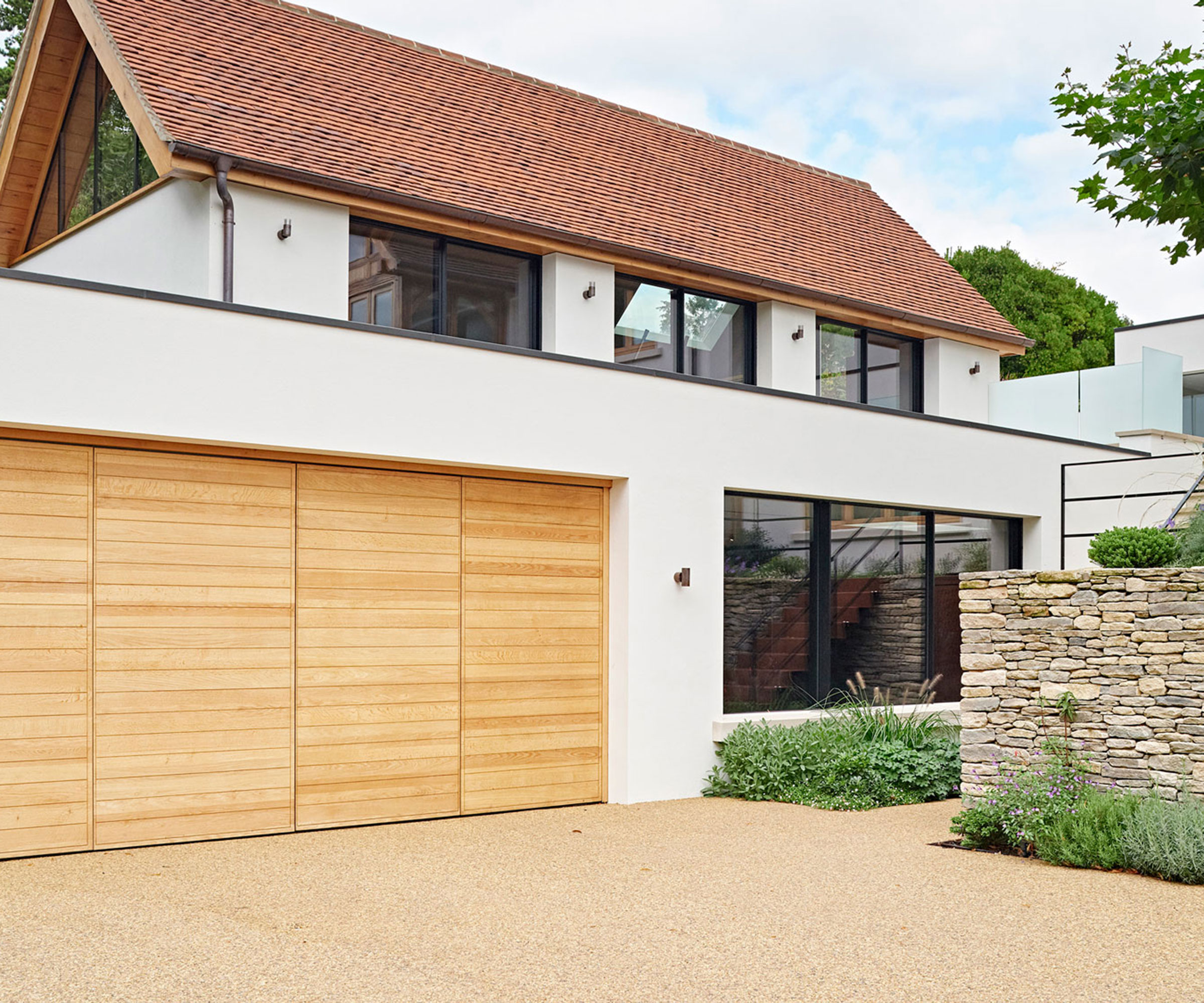 resin driveway in front of modern house with wooden garage doors