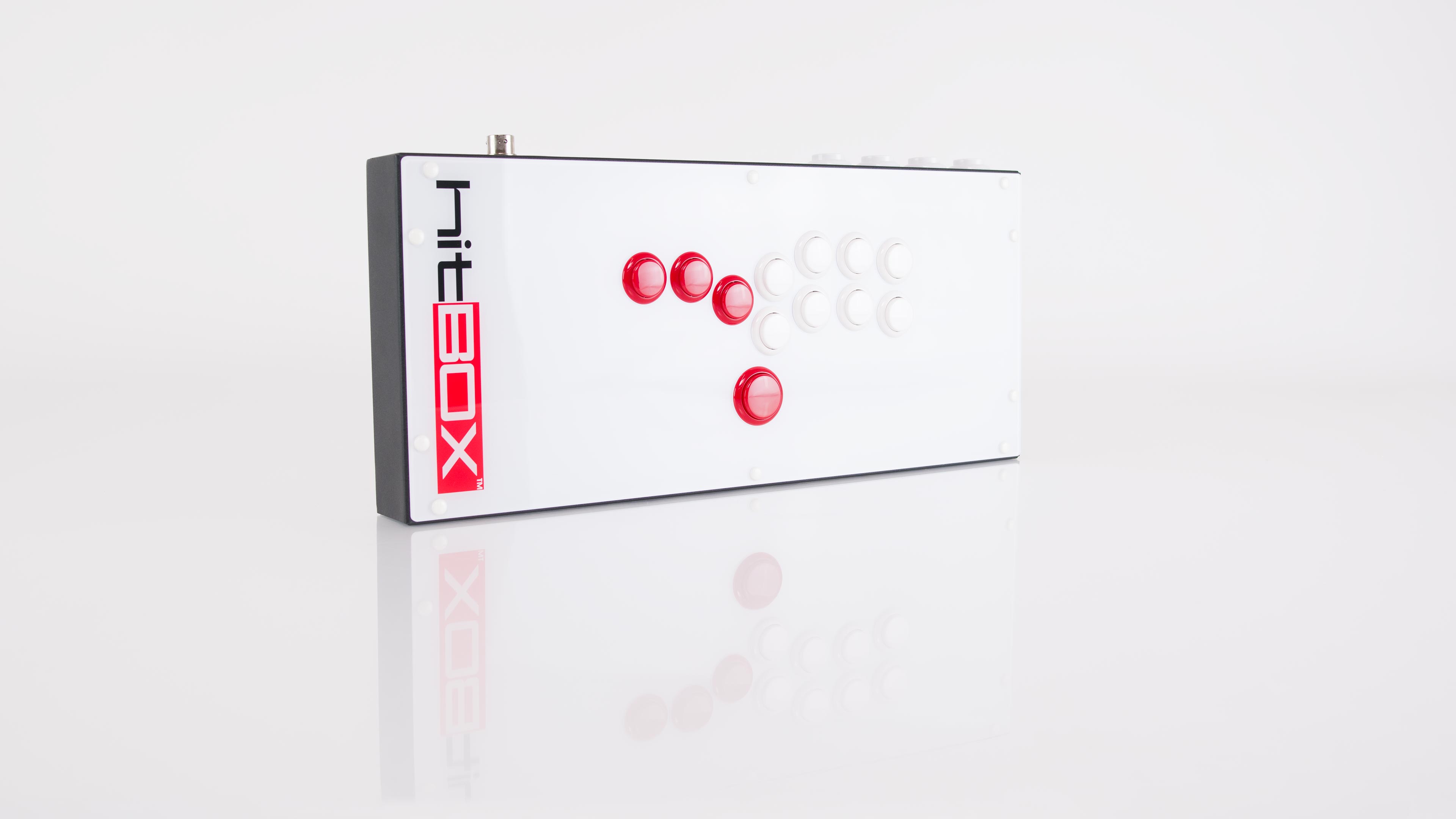 The Hit Box fight controller, placed on a reflective white surface