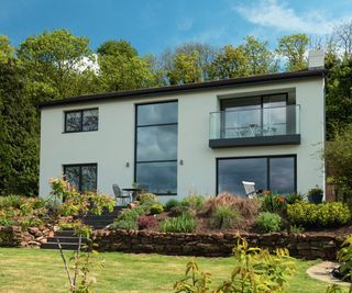 contemporary house with black framed windows finished in cream render