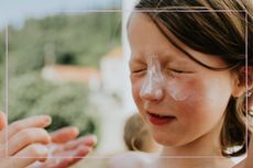 parent putting sunscreen on child