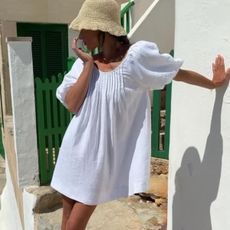 Woman in a white dress and raffia hat