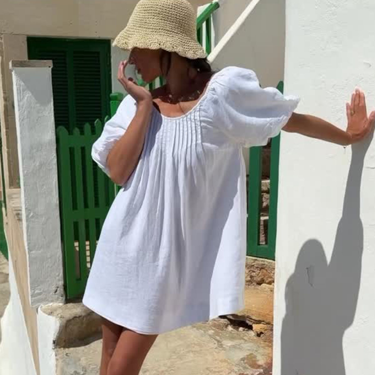 Woman in a white dress and raffia hat