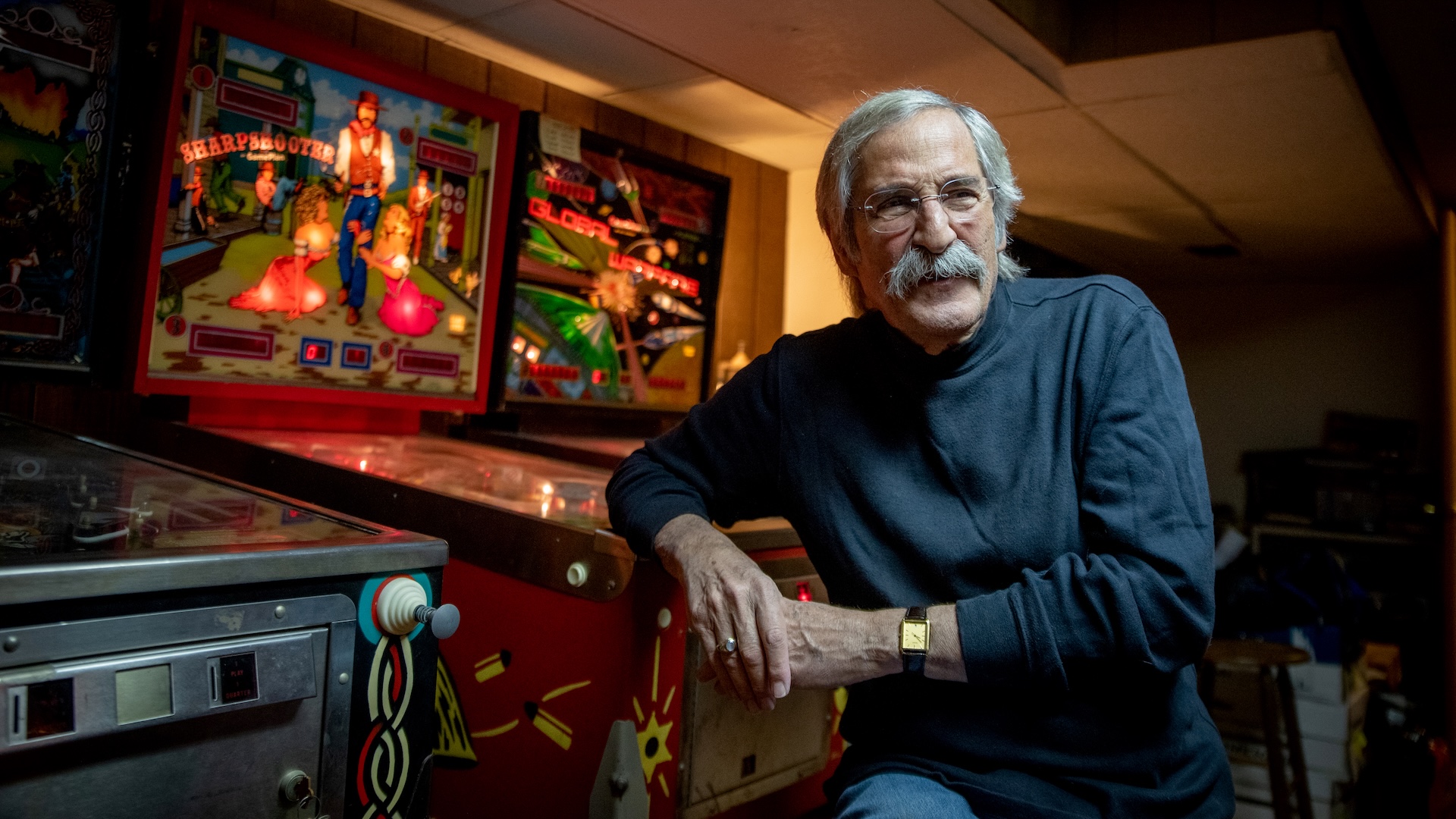 CHICAGO, ILLINOIS - MARCH 22 - Roger Sharpe poses for a portrait in his basement while leaning on Sharpshooter, the game he designed in 1979, in Arlington Heights, Illinois on March 22, 2022. A new movie called Pinball: The Man Who Saved the Game features the game and tells Sharpes 1974 story of playing pinball at a city council hearing to prove it was a game of skill rather than a game of chance, thus ending New York Citys 35-year-ban on the game. He says the experience of having a movie made about him after nearly fifty years is kind of like an out of body experience and hopefully Ill soon drift back to anonymity. (Photo by Kathleen Hinkel for The Washington Post via Getty Images)