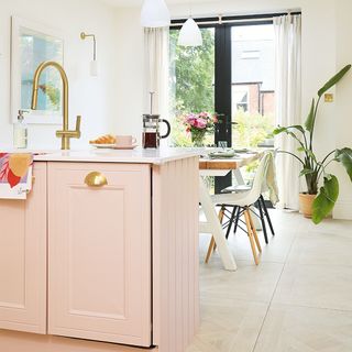 kitchen-diner with pink cabinets and peninsula