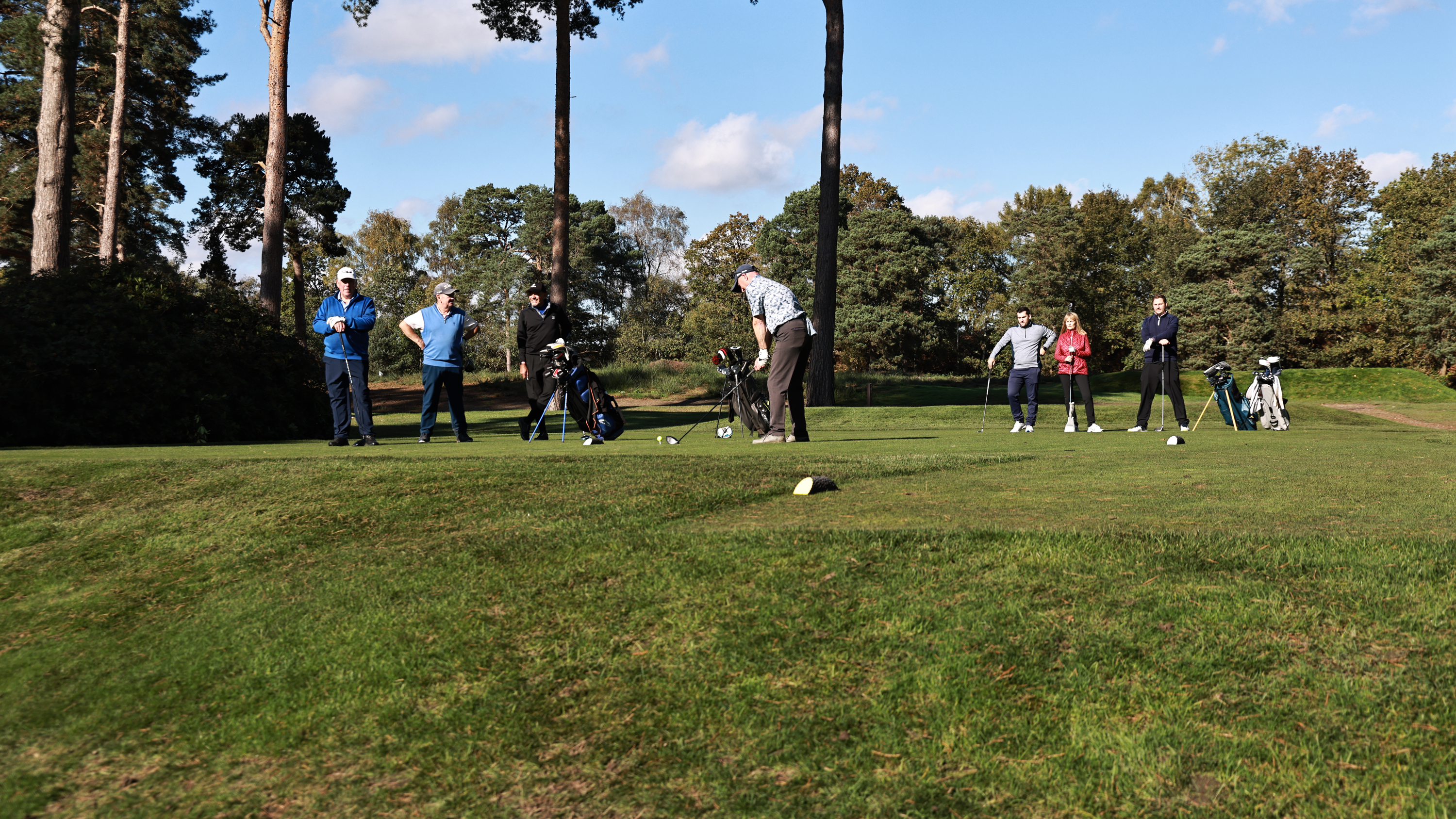 Golfers waiting on a tee