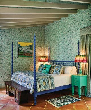Green bedroom with floral wallpaper and four poster bed