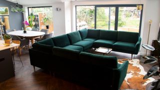 u-shaped green sofa in open plan house