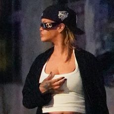 Rihanna wearing a white tank top, a black robe, black shorts, and Puma sneakers in New York City July 2024
