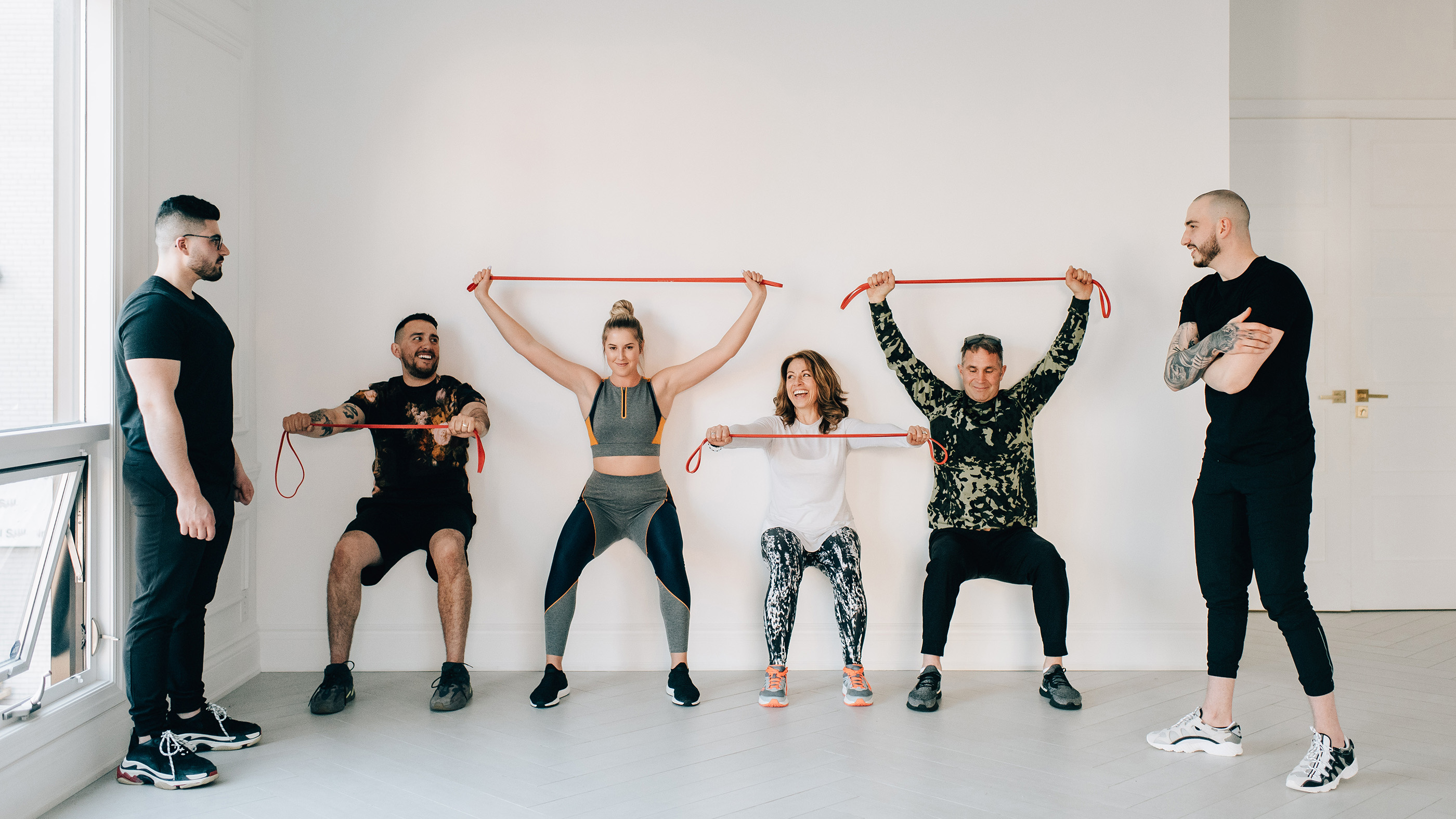 Here, a group of gym goers completes airbench with a resistance band around their hips for strength and stability.