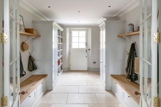 entryway closet with storage, benches, peg rails, shoe storage, stone flags