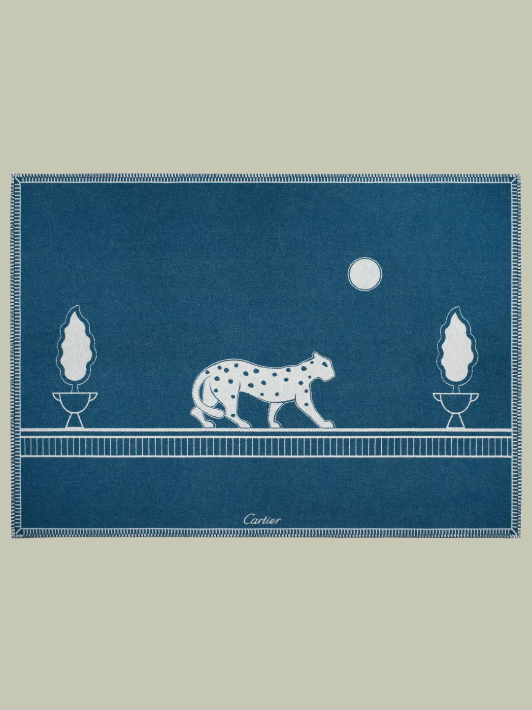 A reversible blue and white throw with a panther from Cartier, made from merino wool and cashmere