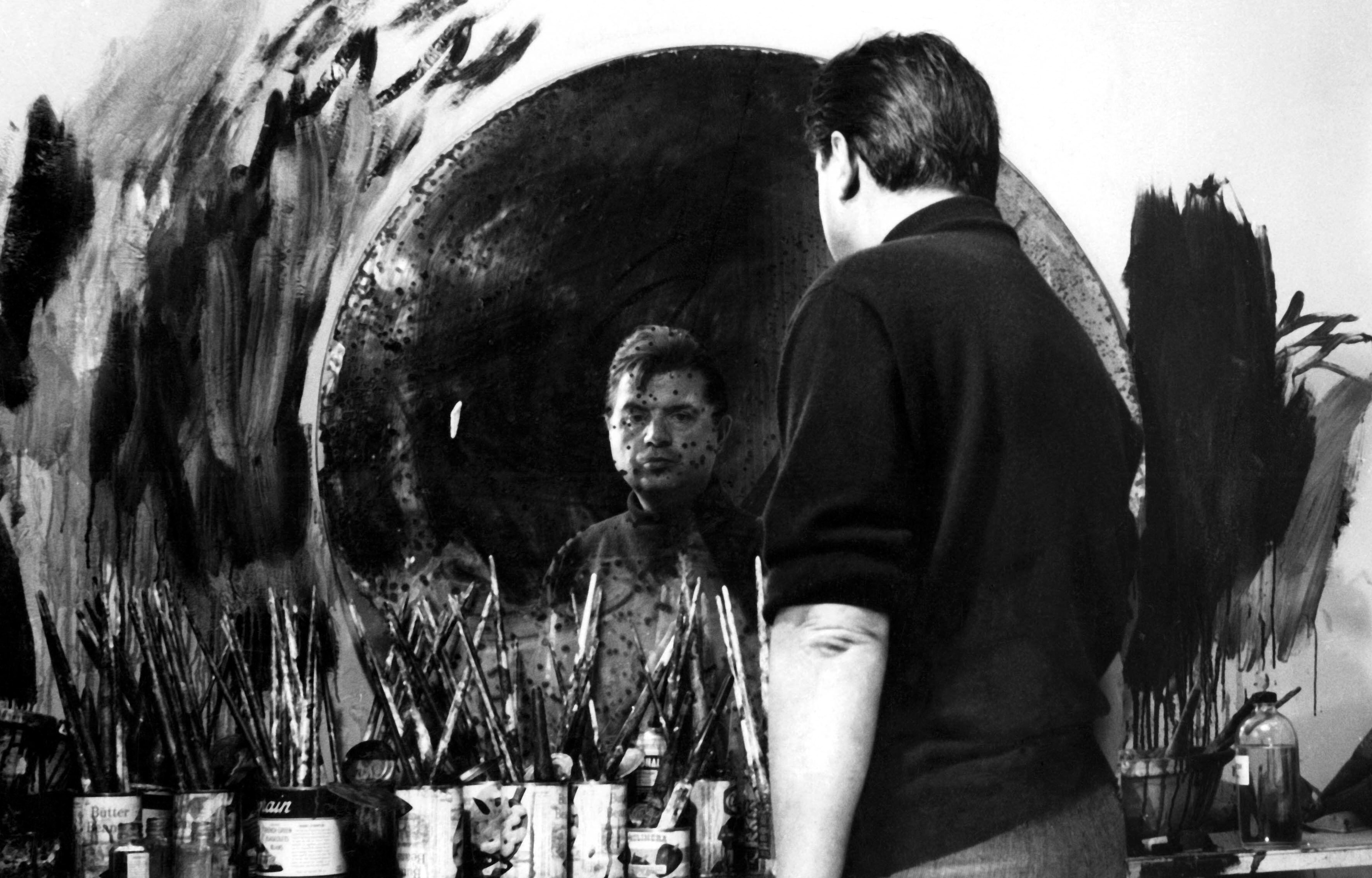 Francis Bacon reflected in his old mirror in the studio.
