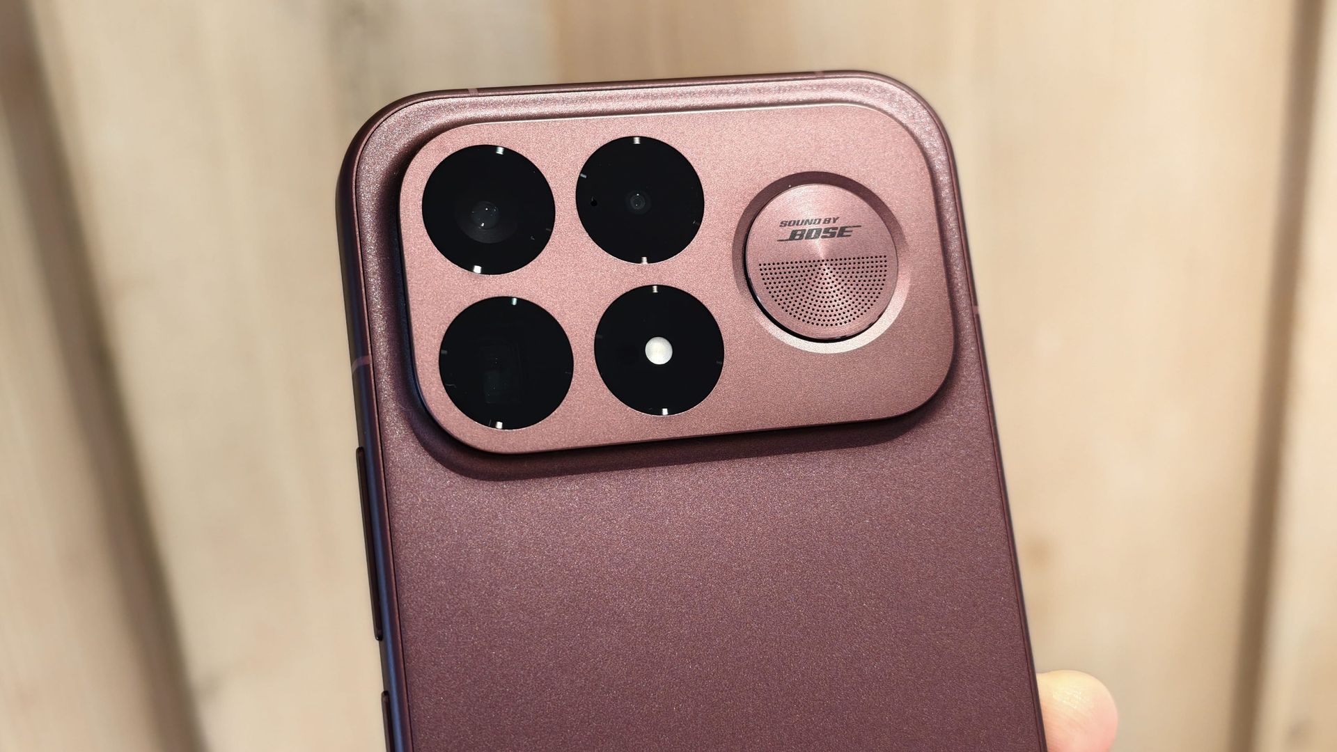 The Poco F9 Ultra being held in the hand and resting on a table