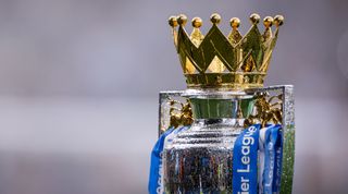 A close-up shot of the Premier League trophy in the rain