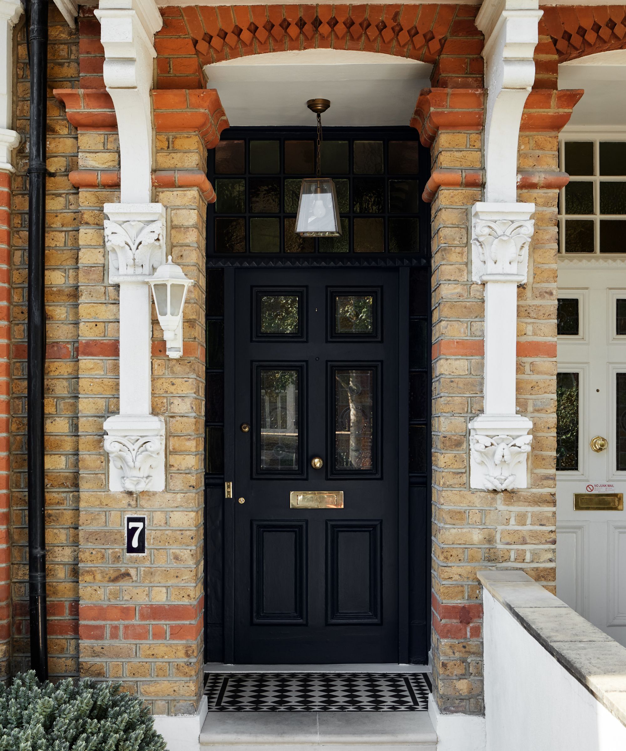 A red brick house with a black front door