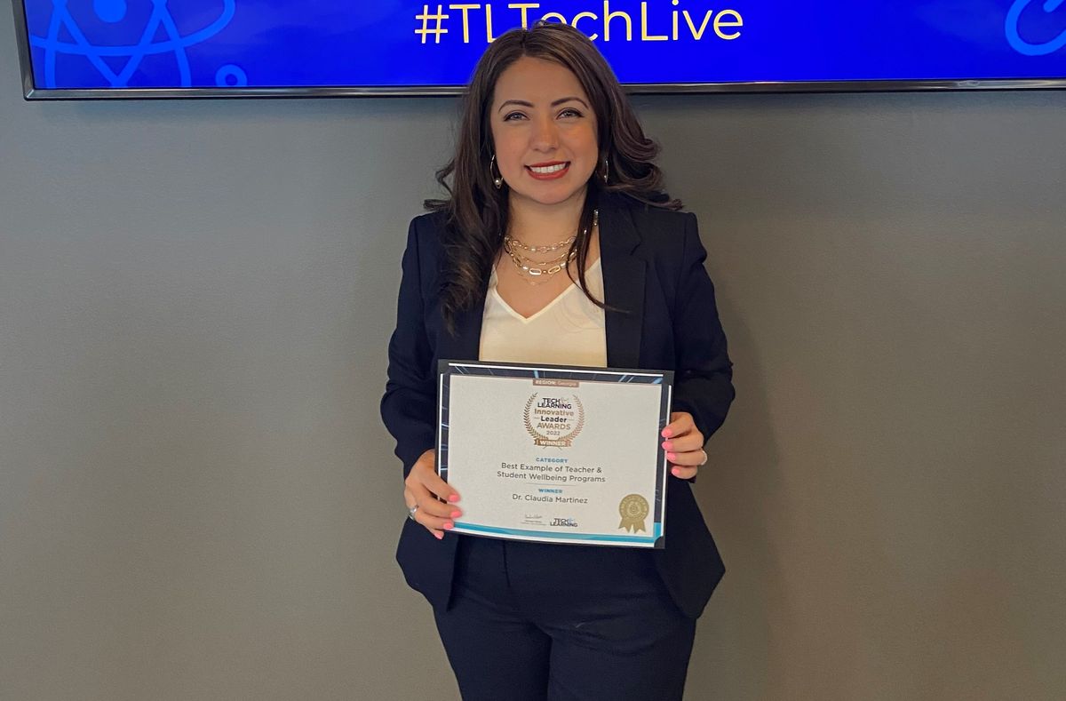 Dr. Claudia Martinez smiles holding her innovative leader award.