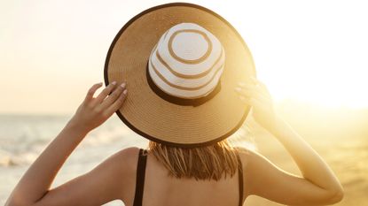 Best SPF for oily skin - woman wearing sun hat looking away from the camera into the sun - gettyimages 1048050676