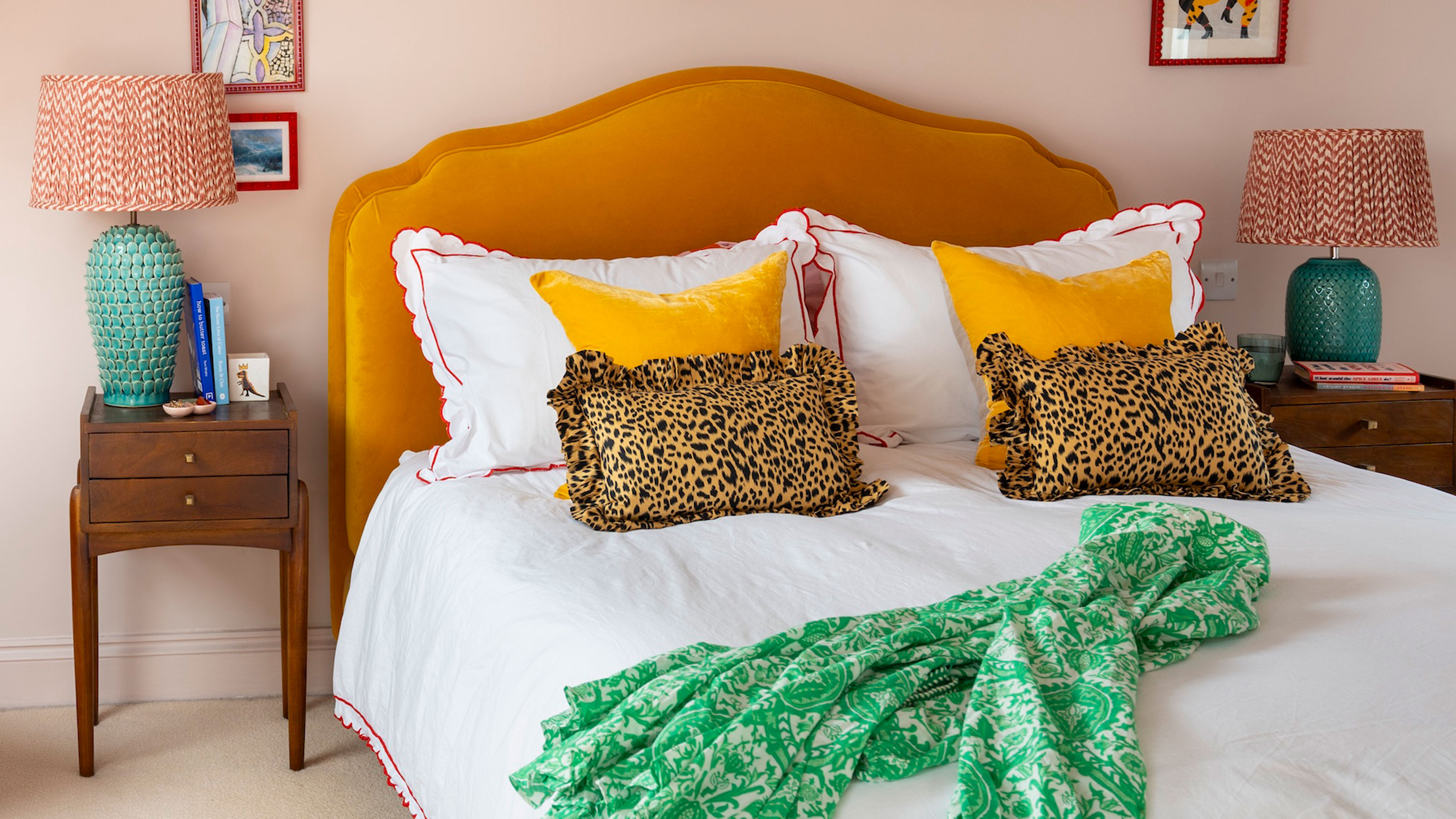 Pink bedroom with double bed with yellow velvet headboard