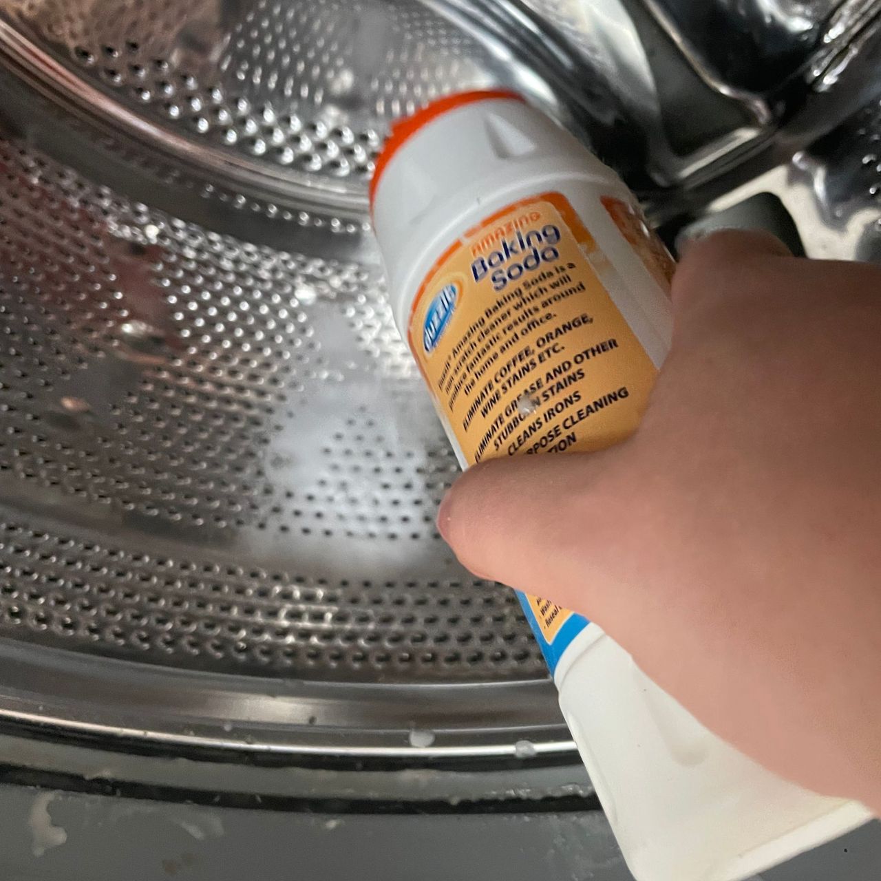 Pouring baking soda into a washing machine drum