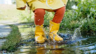 Child jumping in puddle