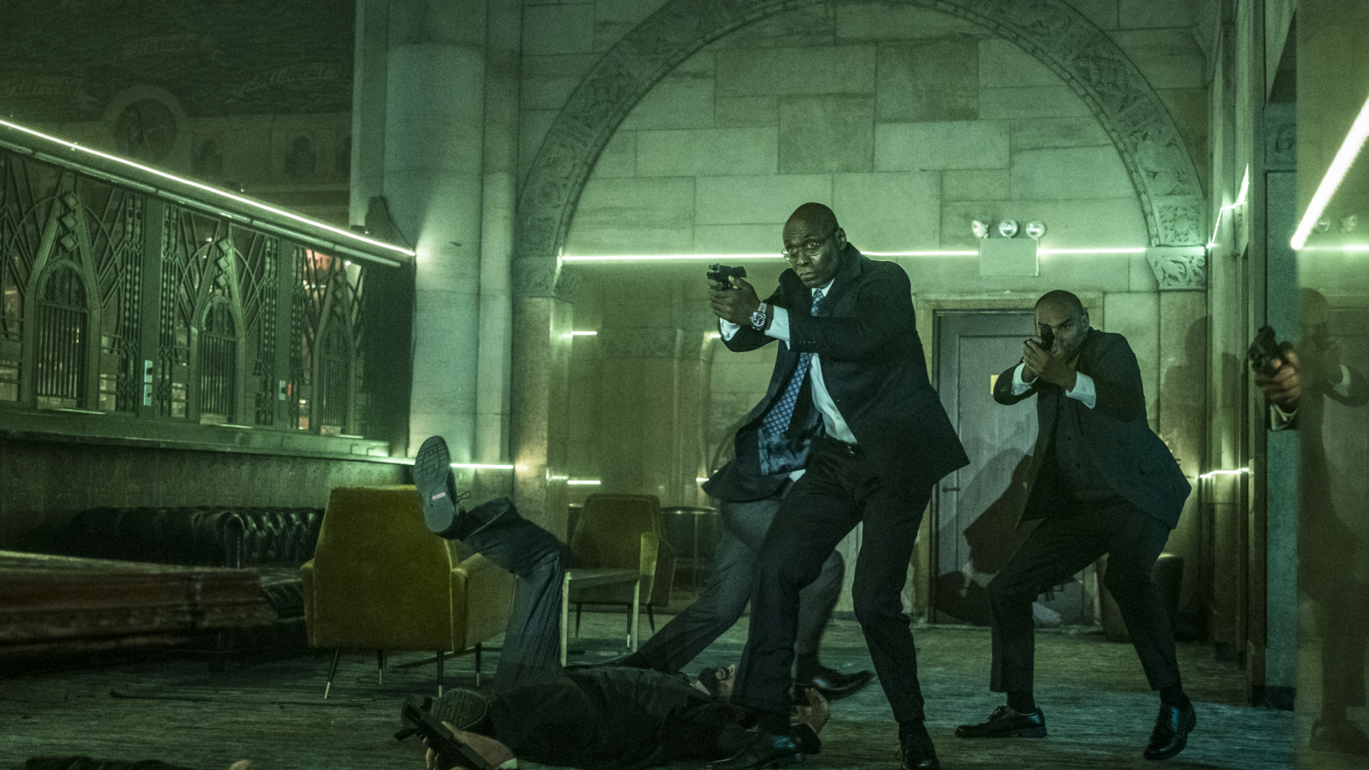 Charon draws his sidearm alongside other assassins in John Wick 2