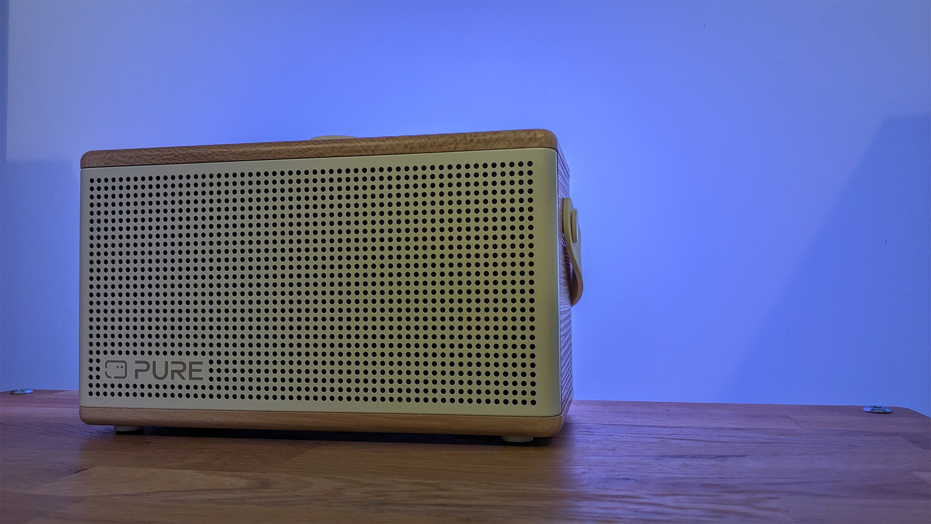 Pure Classic Aura Bluetooth speaker on wooden surface emitting blue light