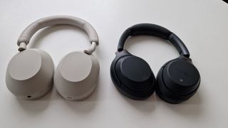 Bästa brusreducerande hörlurar: Ett par beige Sony WH-1000XM5 ligger bredvid ett par svarta Sony WH-1000XM3 på ett vitt bord.