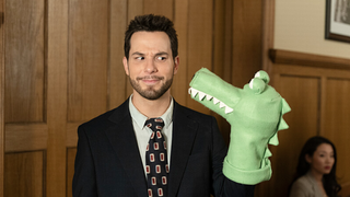 Todd (Skylar Astin) makes a face as he plays with a green puppet in a courtroom in So Help Me Todd season 2