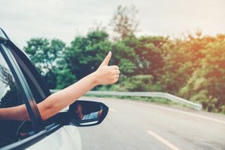 woman waving hand out window